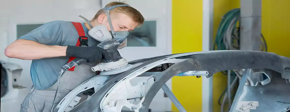 homme avec masque qui répare carrosserie à Montpellier